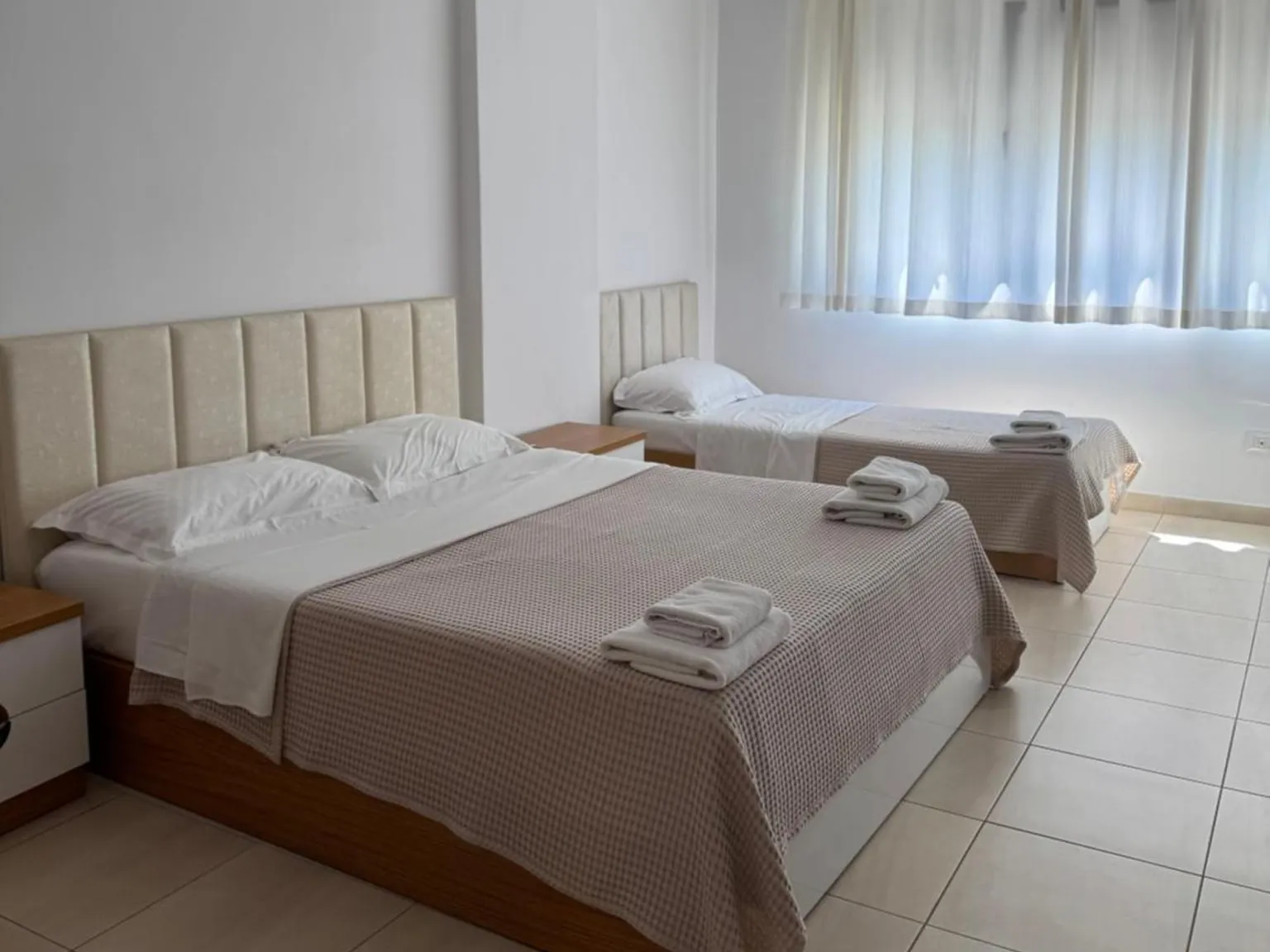 Bright bedroom with a double bed and a single bed at Casa Italia Apartments in Tirana