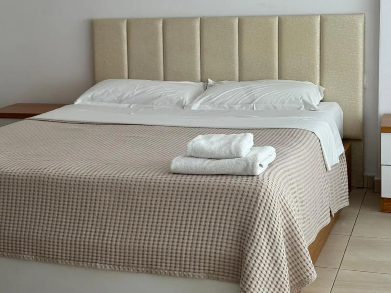 Double bed with fresh towels at Casa Italia Apartments